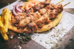 Meat skewers on a wooden background