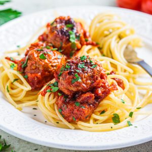 Spaghetti pasta with meatballs in tomato sauce and herbs