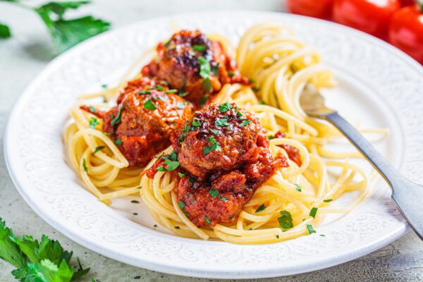 Spaghetti pasta with meatballs in tomato sauce and herbs